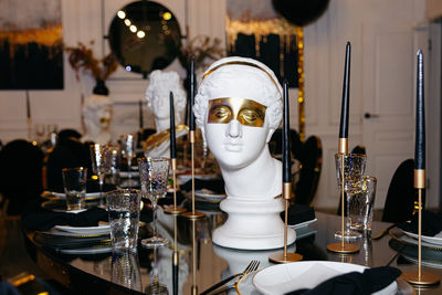 Exquisite table arrangement featuring champagne glasses and a white marble bust of a greek goddess