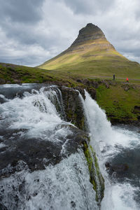 Icelandic waterfall with kirkjufell mountain in the background.
