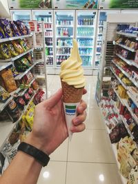 Midsection of ice cream cone at store