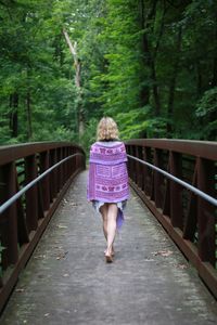 Rear view of woman walking in forest