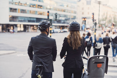 Rear view of people walking on street in city