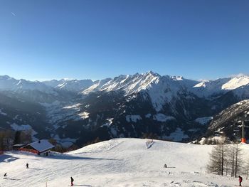 Scenic view of snowcapped mountains against clear blue sky