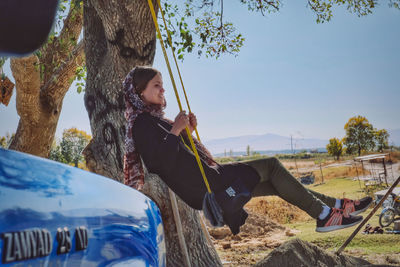 Man sitting by tree trunk