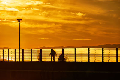 Silhouette people against sky during sunset