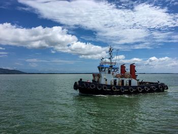 Scenic view of tugboat at sea against sky