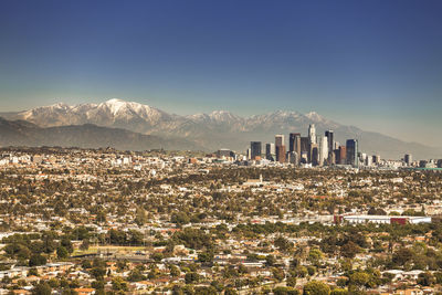 Aerial view of buildings in city against clear sky