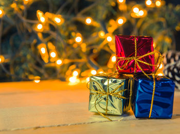 Close-up of christmas present against illuminated lights