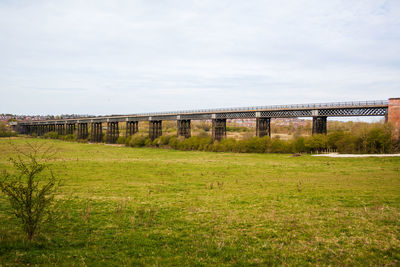 View of railroad tracks on field against sky