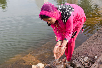 High angle view of woman with pink umbrella on lake