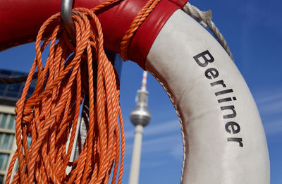 Close-up of rope tied to metal against blue sky