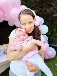 Portrait of a smiling girl with pink balloons