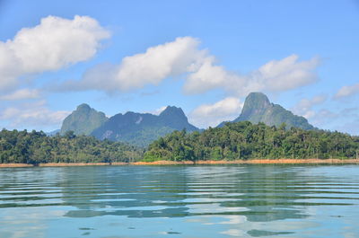 Scenic view of lake by mountains against sky