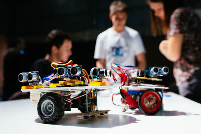 Close-up of remote controlled car with friends standing in background