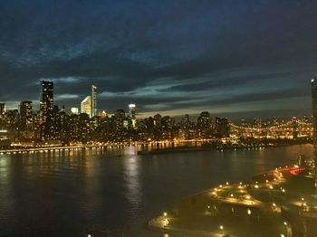 Cityscape by river against sky