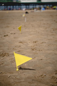 Close-up of arrow sign on sand