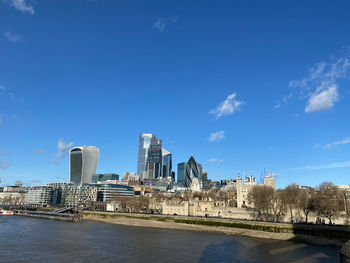 City at waterfront against blue sky