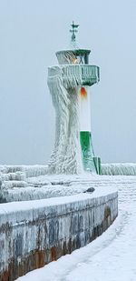 Snow covered sculpture against clear sky