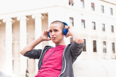 Young woman using mobile phone in city