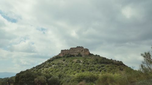 Low angle view of mountain against cloudy sky