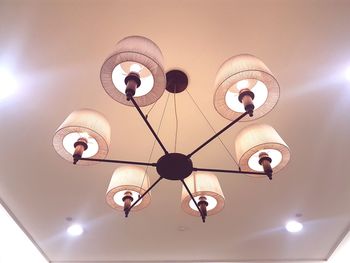 Low angle view of illuminated light bulbs hanging from ceiling