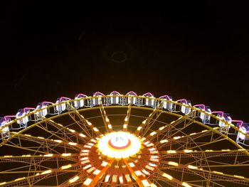 Low angle view of illuminated ferris wheel against sky at night