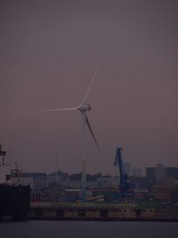 Vapor trails in city against sky