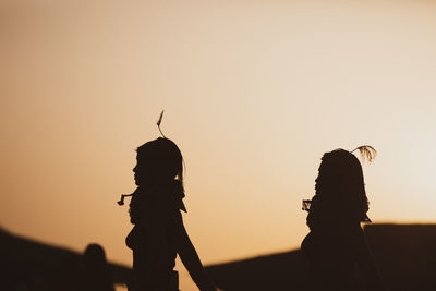 Turkana women standing silhoutte dueing sunset, lake turkana, kenya