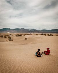 People in desert against sky