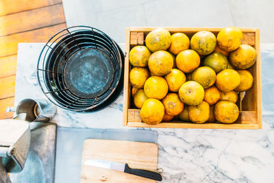 High angle view of fruits in crate by container on table