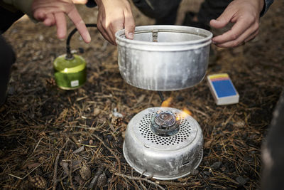 Person putting pot on camping stove