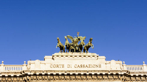Low angle view of statue against blue sky