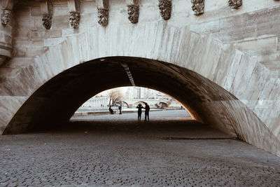 Rear view of silhouette people standing in tunnel