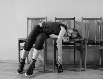 Portrait of boy lying on chairs