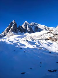 Scenic view of snowcapped mountains against clear blue sky