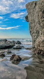 Scenic view of rocks on beach against sky