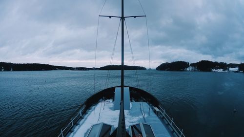 Sailboat in sea against cloudy sky
