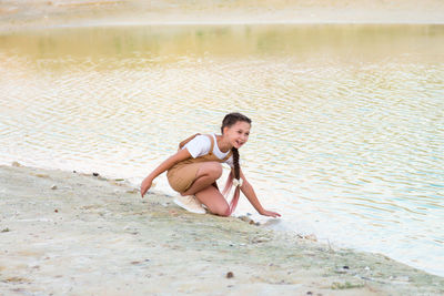 Portrait of young woman sitting in lake