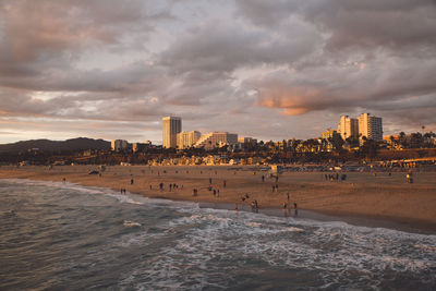 Scenic view of beach against cloudy sky during sunset