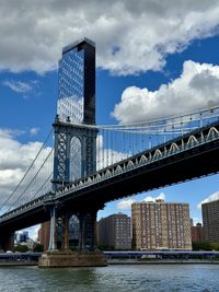 Bridge over river against cloudy sky