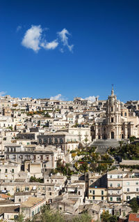 Buildings in city against blue sky