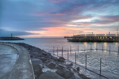 Pier over sea against sky during sunset