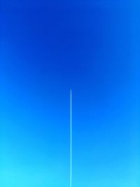 Low angle view of vapor trail against clear blue sky