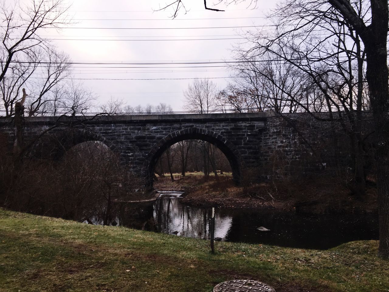 connection, bridge - man made structure, arch, bare tree, arch bridge, architecture, tree, water, built structure, day, river, bridge, nature, transportation, no people, outdoors, sky