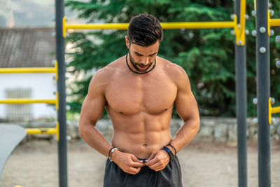 Full length of shirtless man standing outdoors