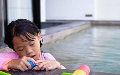 Close-up of cute girl playing with toy on lake