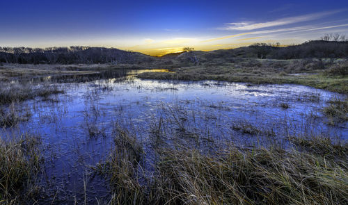 Scenic view of lake against sky during winter