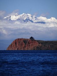 Scenic view of sea and mountains against sky