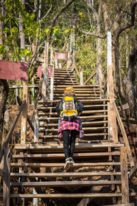 Rear view of backpacker climbing staircases