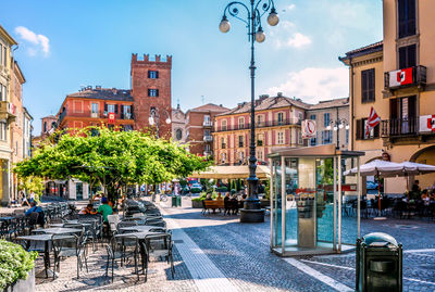 People on street by buildings in city