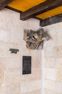 Low angle view of statue against wall